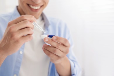 Photo of Man taking contact lens out of case at home, closeup. Space for text