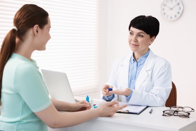 Photo of Ophthalmologist giving contact lenses to patient at table in office