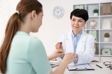 Photo of Ophthalmologist giving contact lenses to patient at table in office