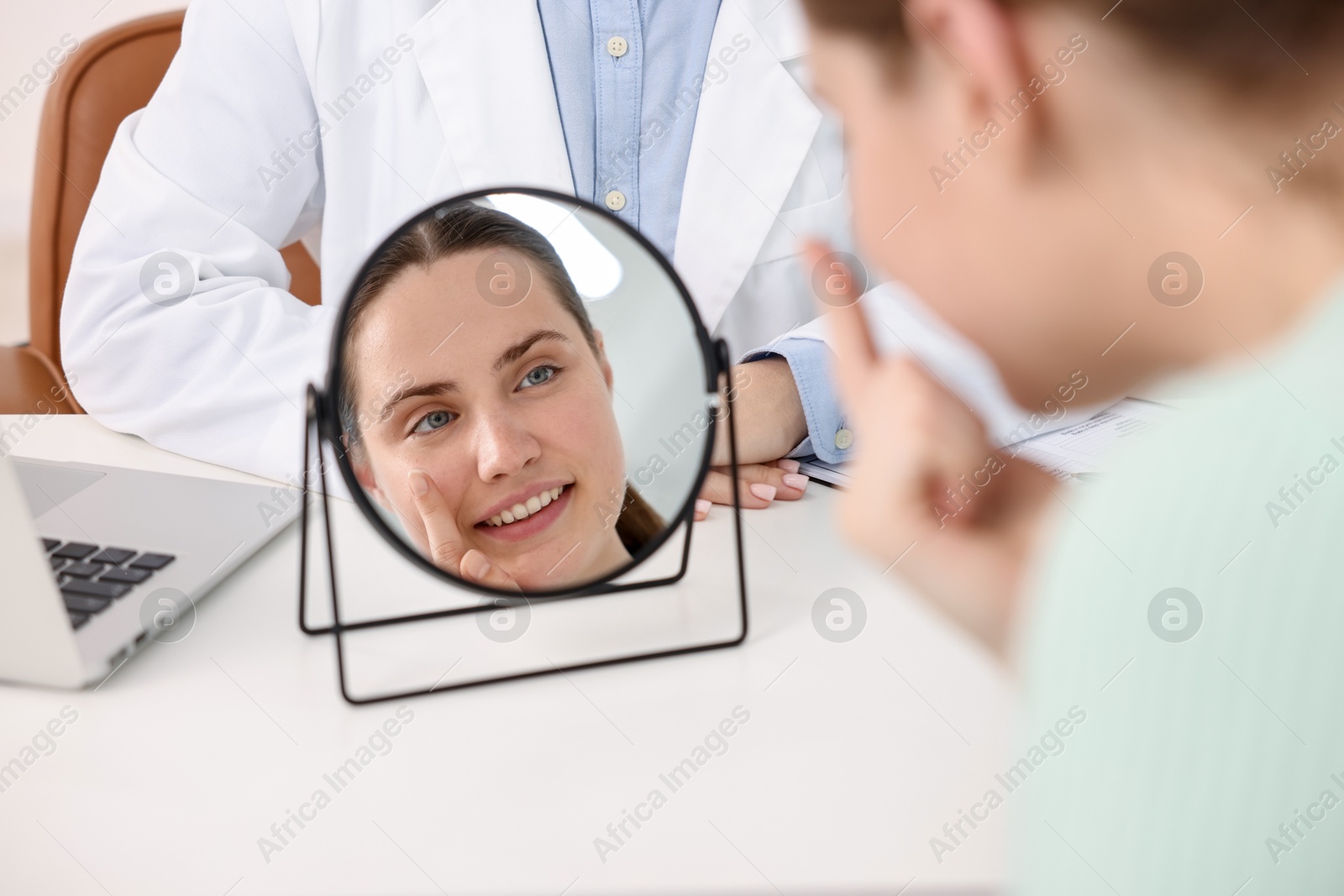 Young woman putting on contact lenses at table near mirror in ophthalmologist office, selective focus Photo of Young woman putting on contact lenses at table near mirror in ophthalmologist office, selective focus
