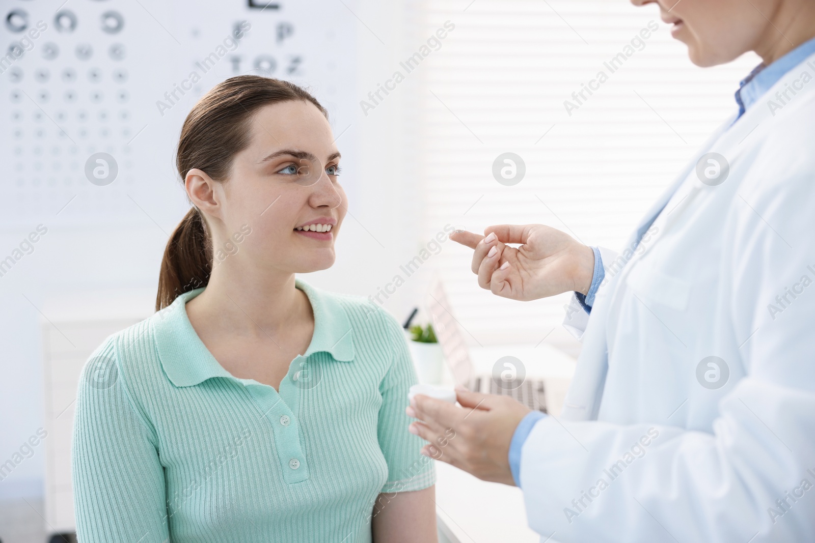 Ophthalmologist giving contact lenses to patient in office, closeup Photo of Ophthalmologist giving contact lenses to patient in office, closeup