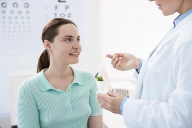 Photo of Ophthalmologist giving contact lenses to patient in office, closeup