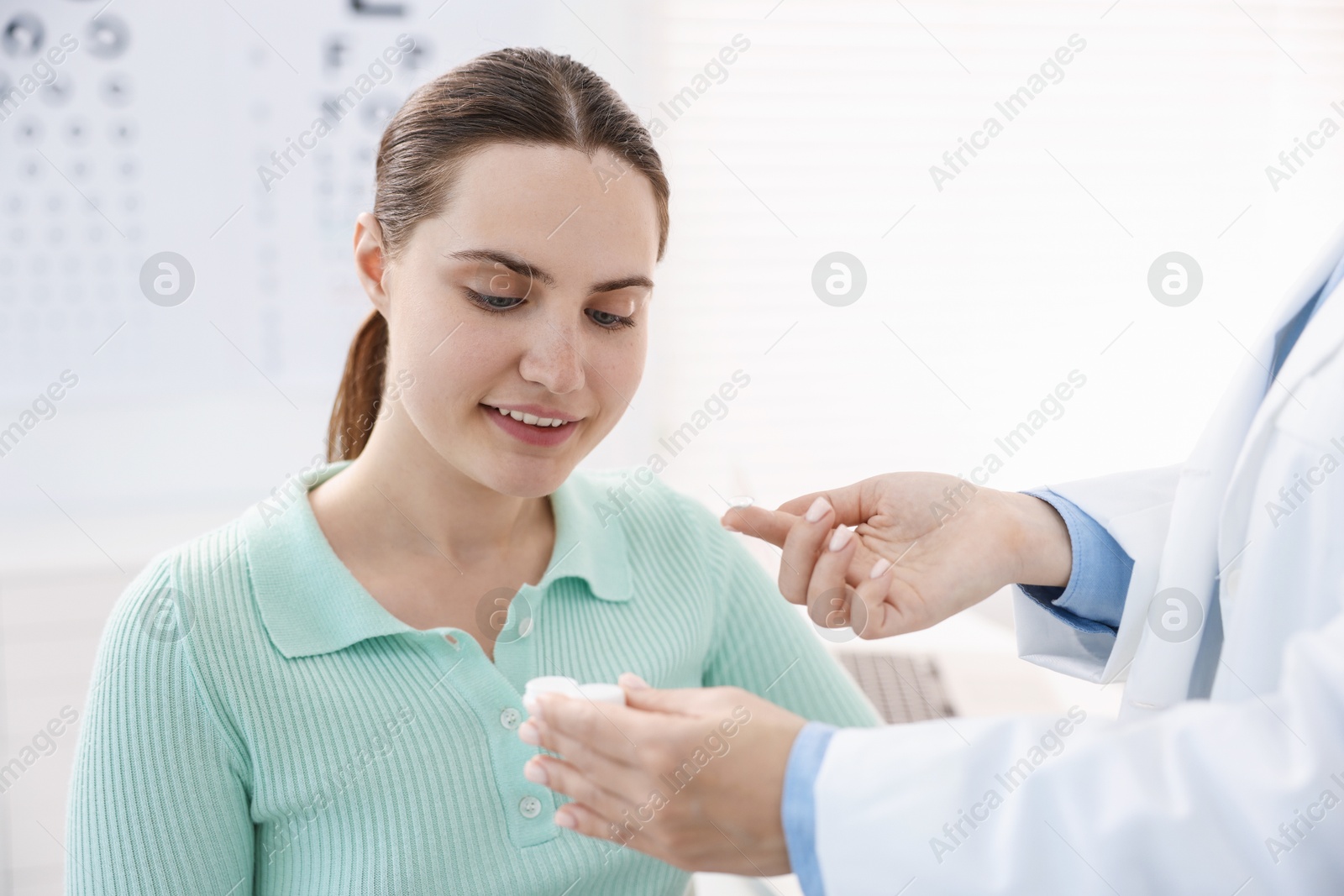 Ophthalmologist giving contact lenses to patient in office, closeup Photo of Ophthalmologist giving contact lenses to patient in office, closeup