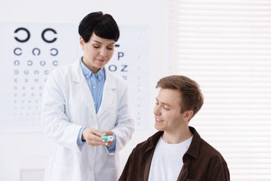 Photo of Ophthalmologist giving contact lenses to patient in office