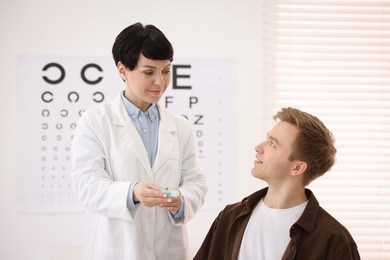 Photo of Ophthalmologist giving contact lenses to patient in office