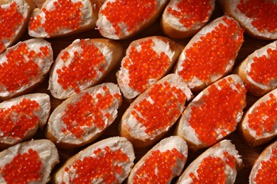 Photo of Buffet menu. Sandwiches with red caviar on table, top view