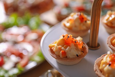 Photo of Buffet menu. Tasty stuffed tartlets on stand, closeup