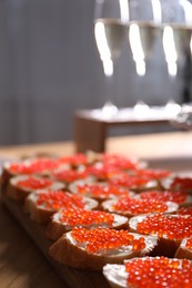 Photo of Buffet menu. Sandwiches with red caviar on wooden table, closeup