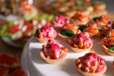 Photo of Buffet menu. Tasty stuffed tartlets on stand, closeup