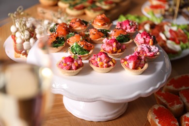 Photo of Buffet menu. Tasty stuffed tartlets on stand, closeup