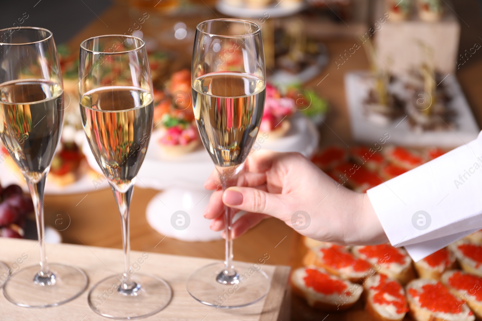 Buffet menu. Woman taking glass of sparkling wine from table, closeup Photo of Buffet menu. Woman taking glass of sparkling wine from table, closeup