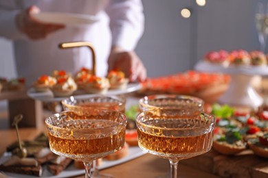 Photo of Buffet menu. Woman taking tasty tartlet from table, selective focus