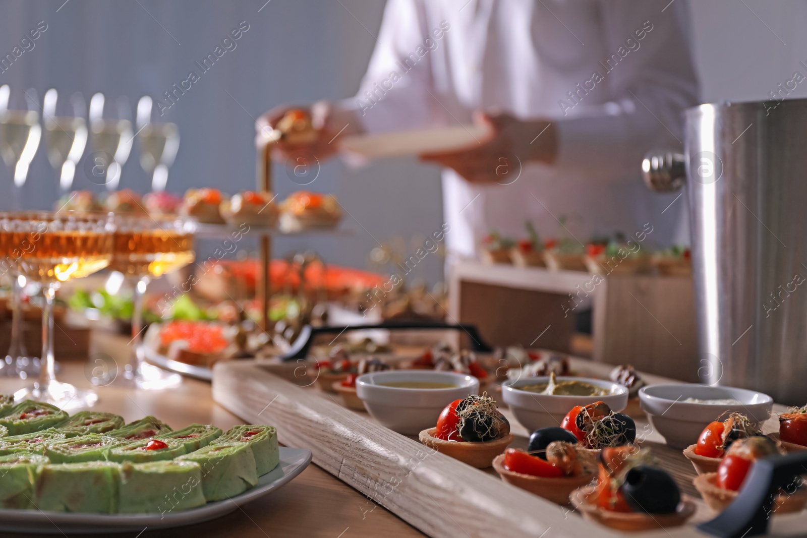 Buffet menu. Woman taking tasty tartlet from table, selective focus Photo of Buffet menu. Woman taking tasty tartlet from table, selective focus
