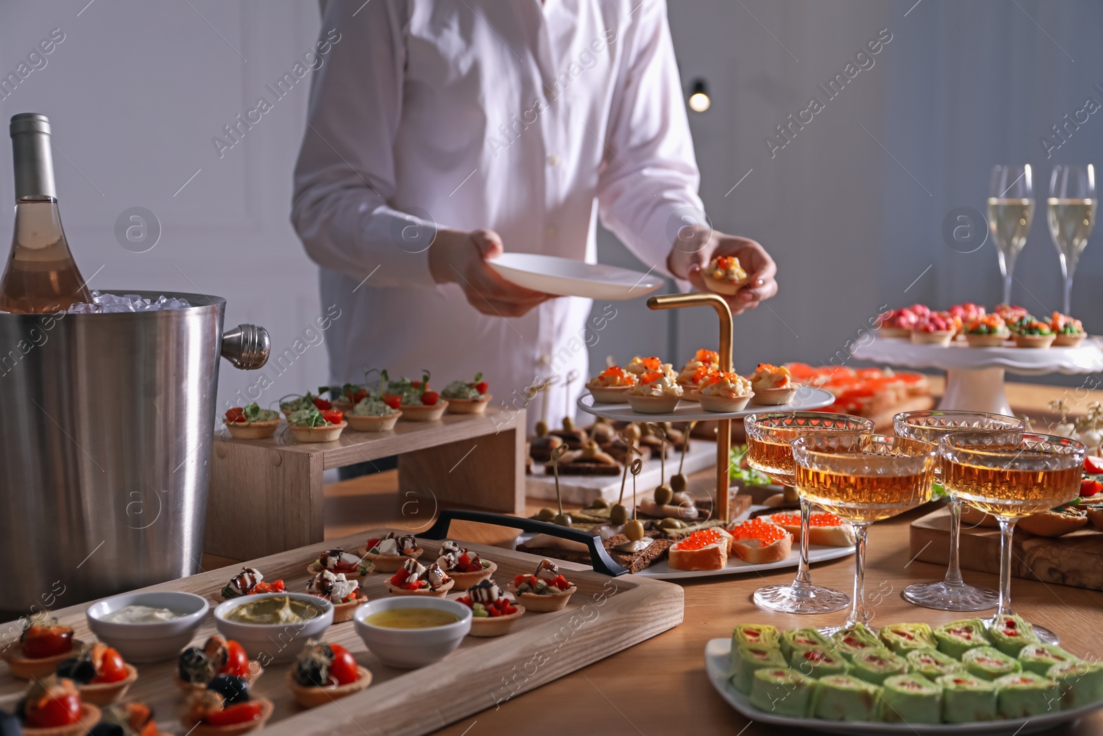 Buffet menu. Woman taking tasty tartlet from table, closeup Photo of Buffet menu. Woman taking tasty tartlet from table, closeup