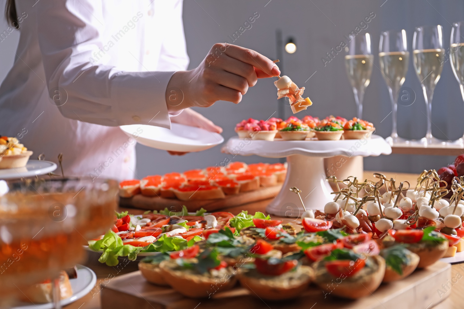 Buffet menu. Woman taking tasty canape from table, closeup Photo of Buffet menu. Woman taking tasty canape from table, closeup