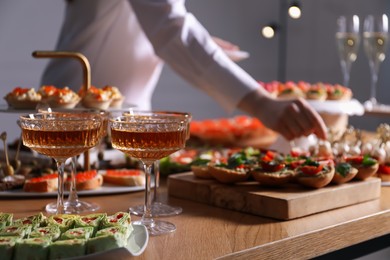 Photo of Buffet menu. Woman taking tasty canape from table, closeup