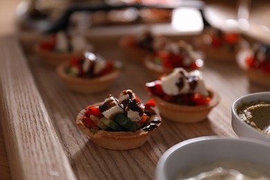 Photo of Buffet menu. Tasty stuffed tartlets on table, closeup