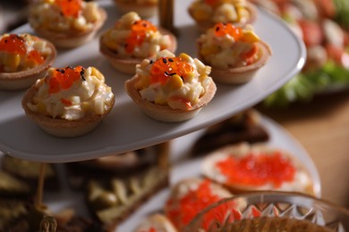 Photo of Buffet menu. Tasty stuffed tartlets on stand, closeup