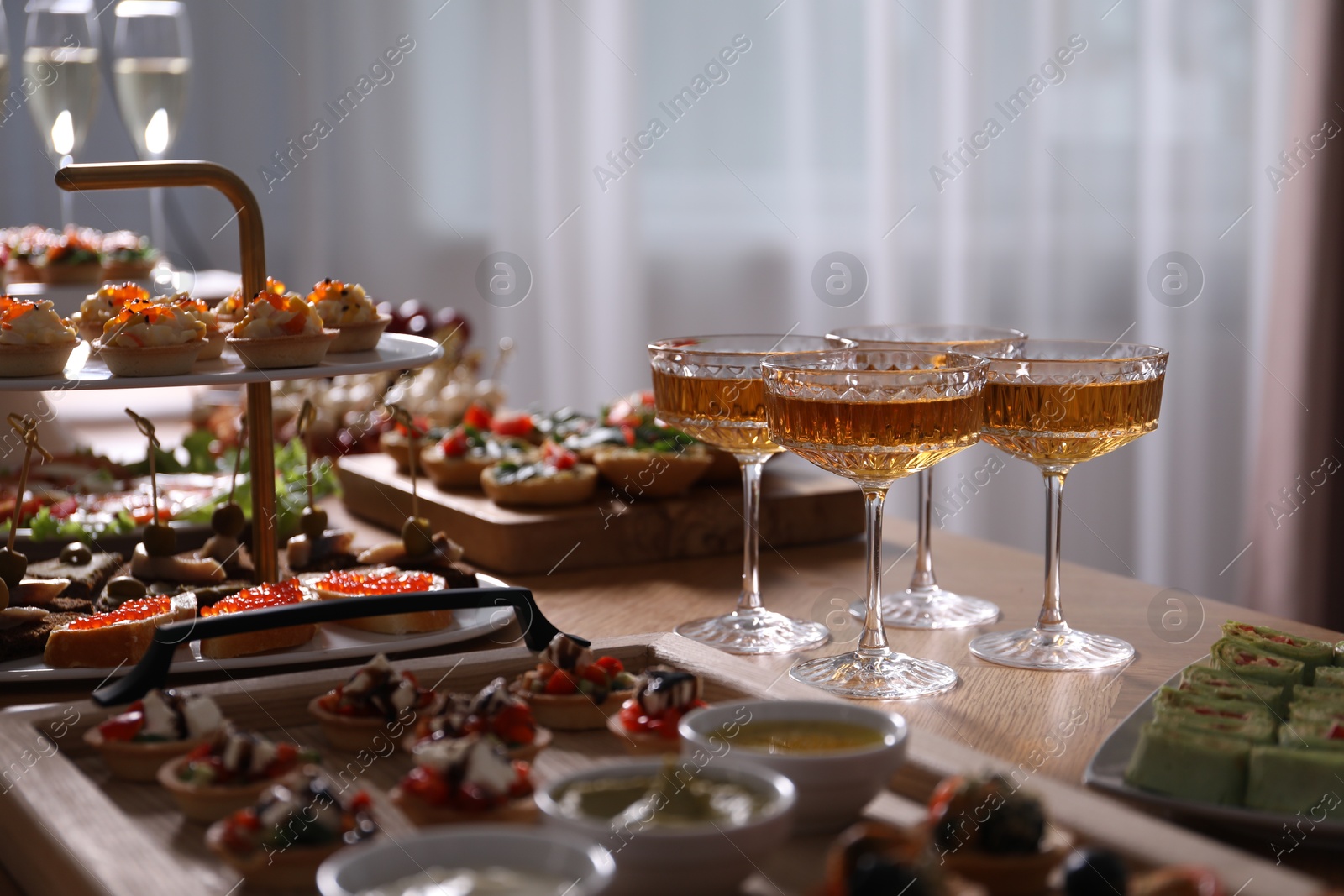Buffet menu. Glasses of sparkling wine and tasty appetizers on table, closeup Photo of Buffet menu. Glasses of sparkling wine and tasty appetizers on table, closeup