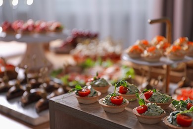 Photo of Buffet menu. Tasty stuffed tartlets on stand, closeup