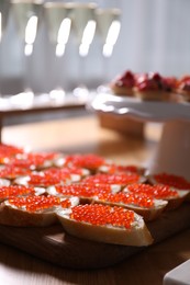 Photo of Buffet menu. Tasty sandwiches with red caviar on table, closeup
