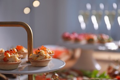 Photo of Buffet menu. Tasty stuffed tartlets on stand, closeup
