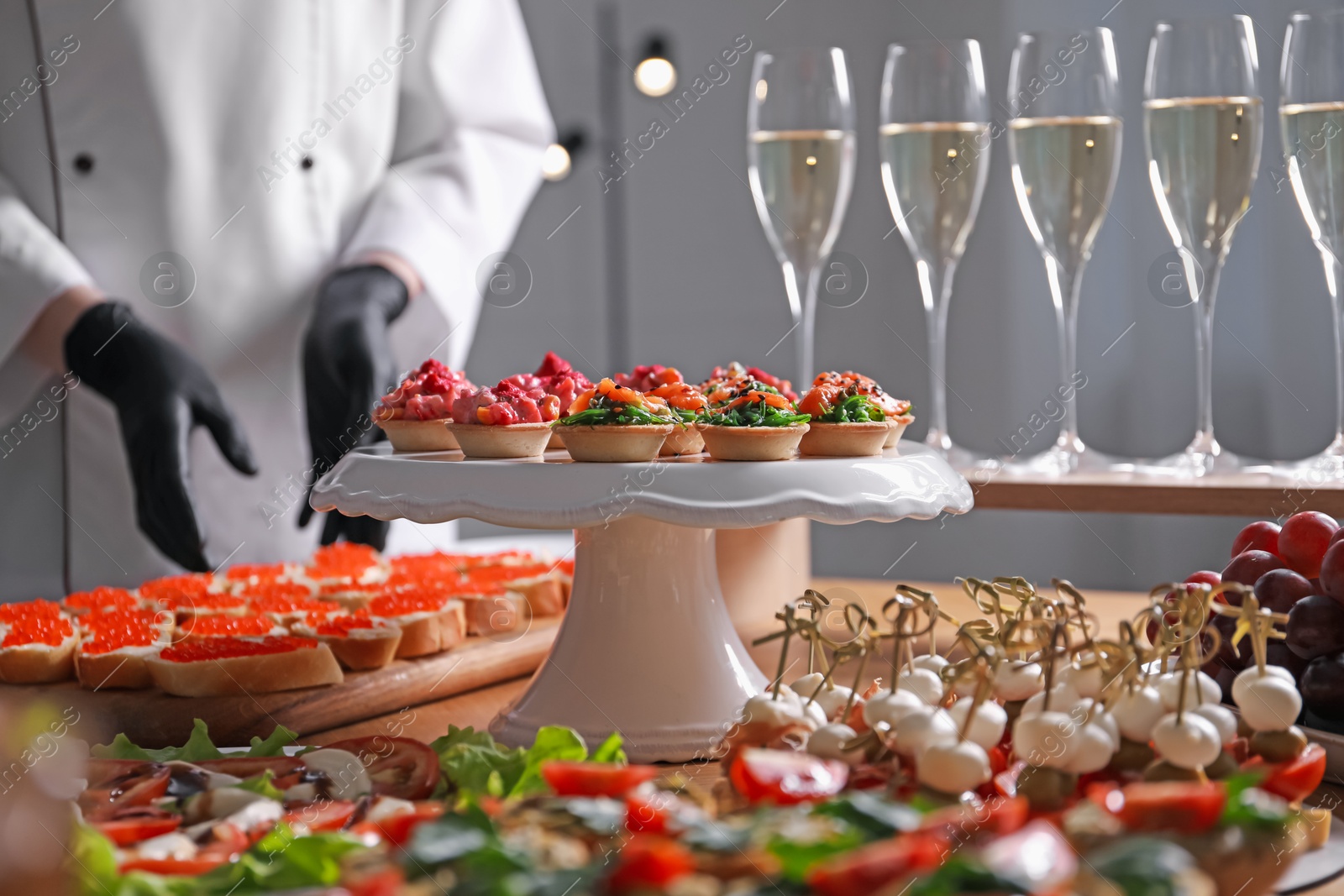 Chef arranging appetizers on buffet table, selective focus Photo of Chef arranging appetizers on buffet table, selective focus