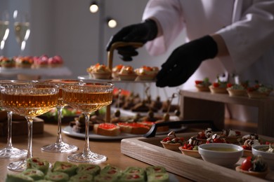 Photo of Chef arranging appetizers on buffet table, selective focus