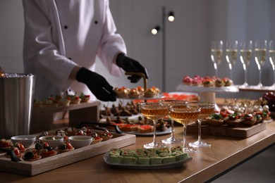 Photo of Chef arranging appetizers on buffet table, selective focus