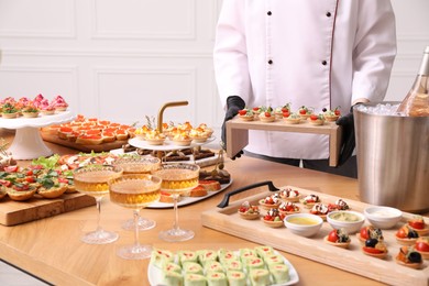 Photo of Chef arranging appetizers on buffet table, closeup