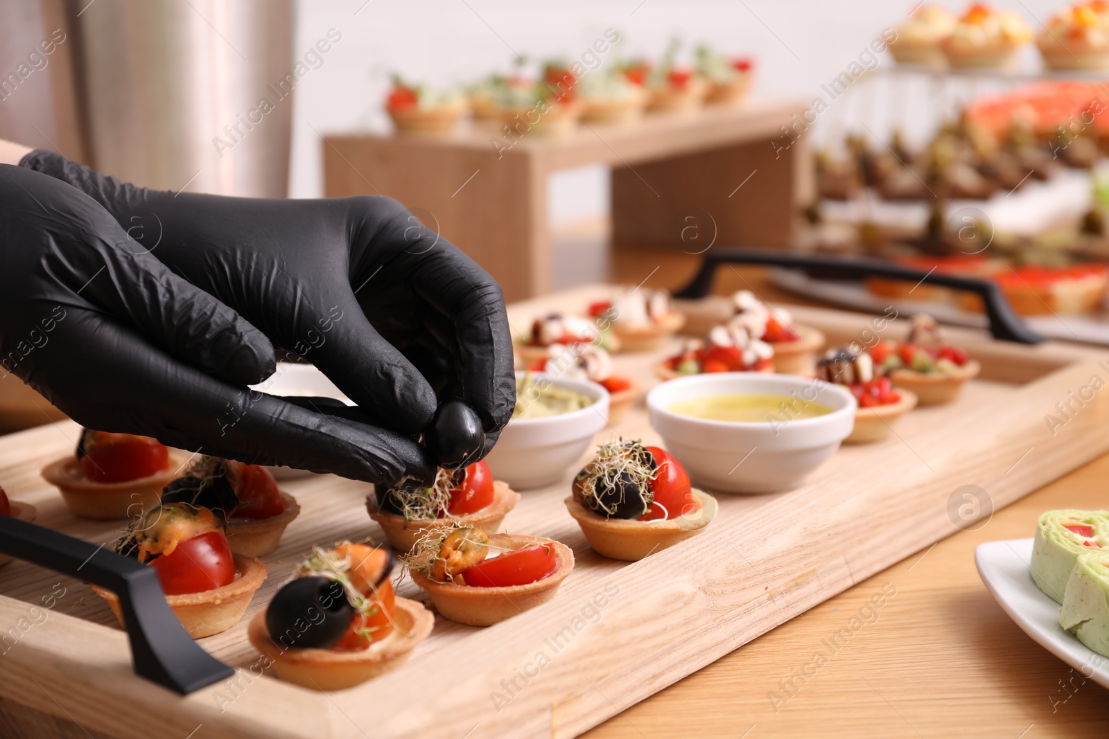 Chef arranging appetizers on buffet table, closeup Photo of Chef arranging appetizers on buffet table, closeup