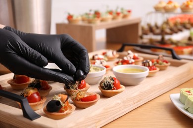 Photo of Chef arranging appetizers on buffet table, closeup