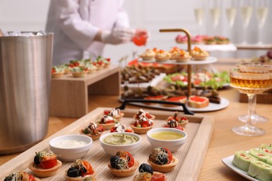 Photo of Chef arranging appetizers on buffet table, selective focus