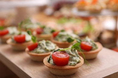 Photo of Buffet menu. Tasty stuffed tartlets on stand, closeup