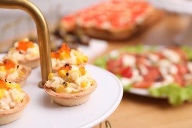 Photo of Buffet menu. Tasty stuffed tartlets on stand, closeup