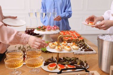 Photo of People with different appetizers at buffet, closeup