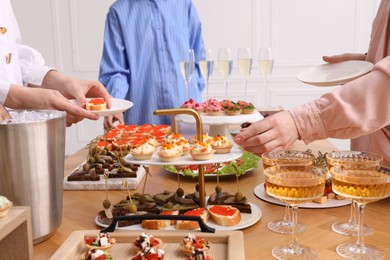 Photo of People with different appetizers at buffet, closeup