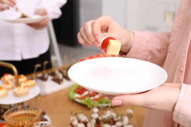 Photo of Buffet menu. Woman taking tasty canape from table, closeup