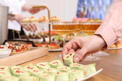 Photo of Buffet menu. Woman taking tasty appetizer from table, closeup