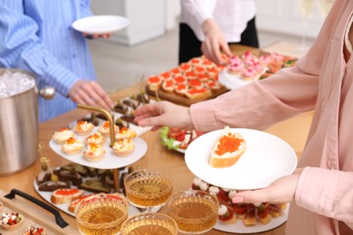 Photo of People with different appetizers at buffet, closeup
