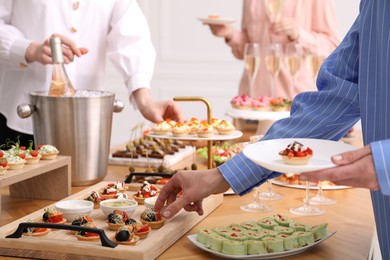 Photo of People with different appetizers at buffet, closeup