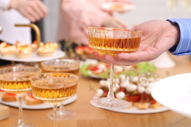 Photo of Buffet menu. Woman taking glass of sparkling wine from table, closeup