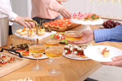 Photo of People with different appetizers at buffet, closeup