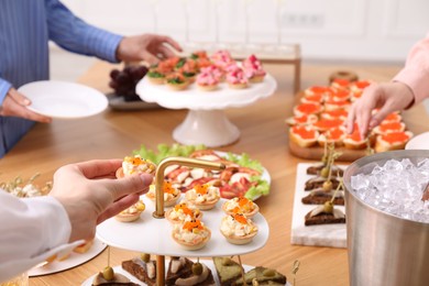 Photo of People with different appetizers at buffet, closeup