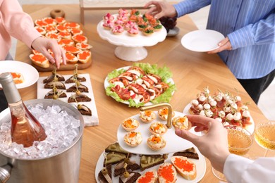 Photo of People with different appetizers at buffet, closeup