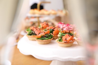 Photo of Buffet menu. Tasty stuffed tartlets on stand, closeup