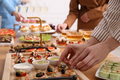 Photo of People with different appetizers at buffet, selective focus