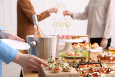 Photo of People with different appetizers at buffet, selective focus
