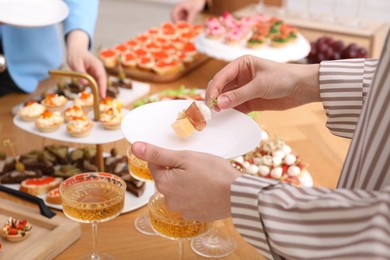 Photo of People with different appetizers at buffet, selective focus