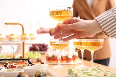Photo of Buffet menu. Woman taking glass of sparkling wine from table, closeup